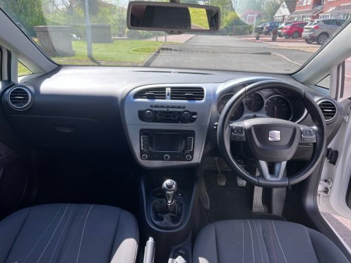 Interior of a car featuring a dashboard, steering wheel, and front seats.