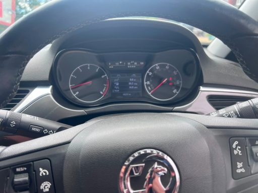 Close-up of a car's dashboard showing speed and fuel gauges.