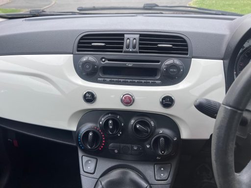 Dashboard of a car with stereo controls and air conditioning knobs.