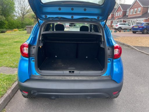Blue car boot open, revealing empty storage space.